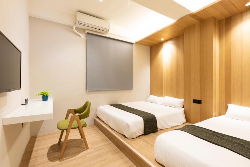 a hotel room with two beds and a projection screen at Meander Taipei Hostel - Ximending in Taipei