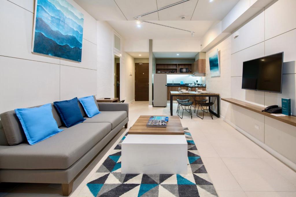 a living room with a couch and a table at The Sphere Serviced Residences Managed by HII in Manila