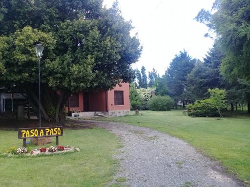 a sign in the grass next to a dirt road at Cabaña Paso a Paso in Tandil