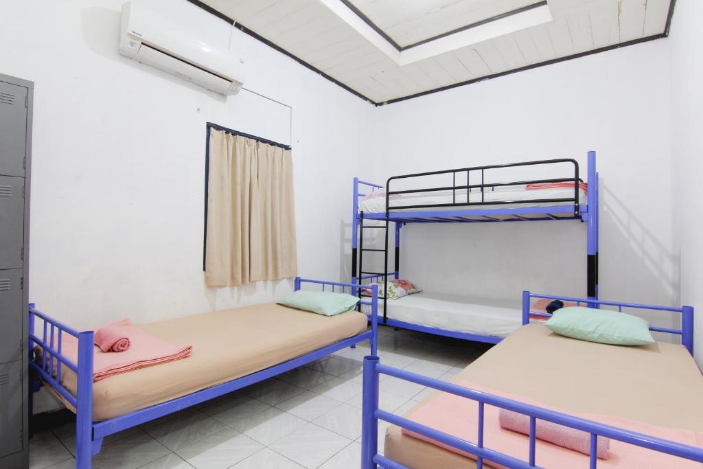 スマランにあるArjuna Hostelの二段ベッド2台と窓が備わる客室です。