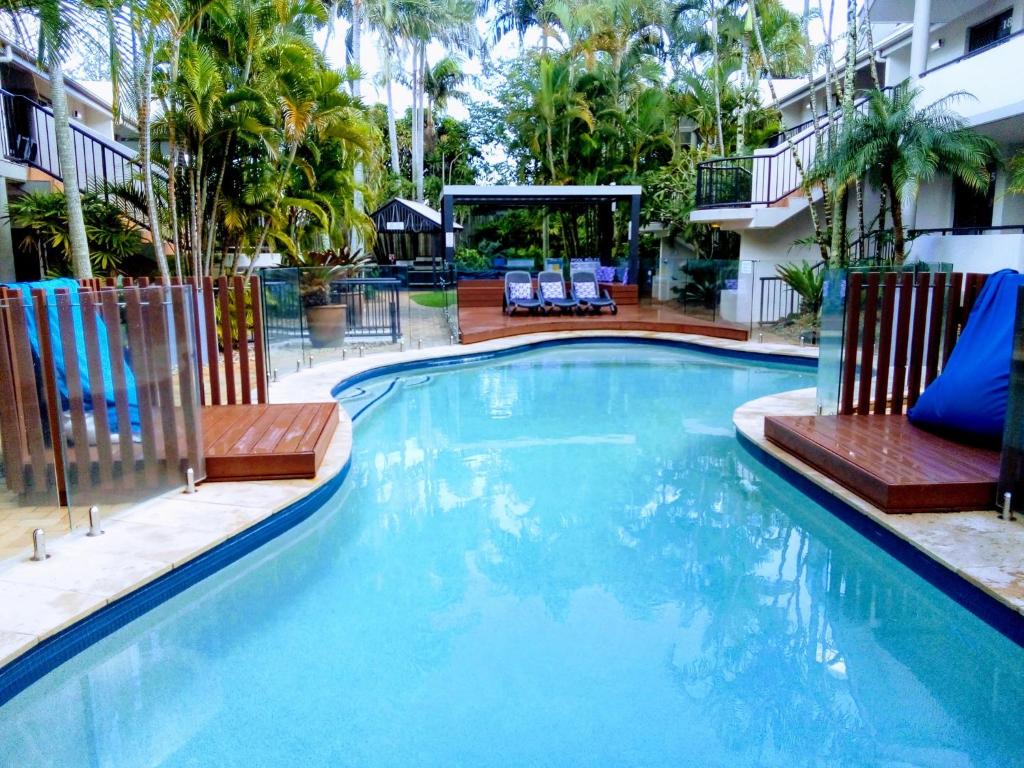 a large swimming pool with two chairs next to a building at Outrigger Bay in Byron Bay