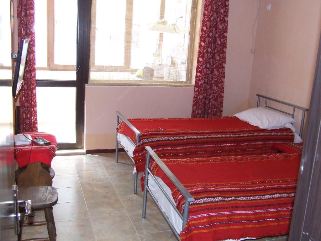 two beds in a room with a window at Varnaflats Guest Rooms in Varna City