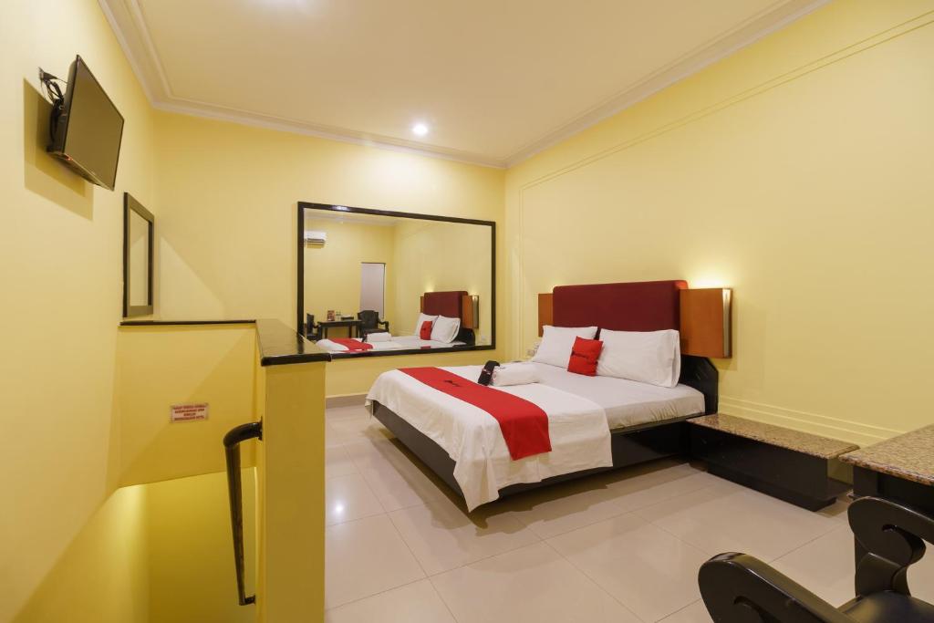 a hotel room with a bed and a mirror at RedDoorz Plus near Ancol in Jakarta