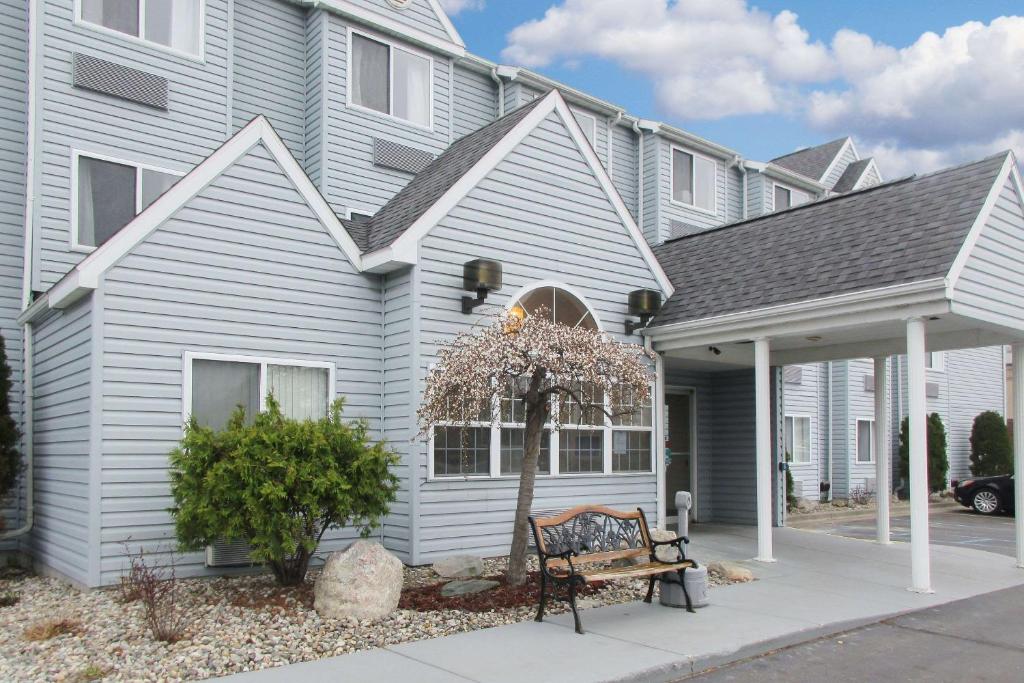 une maison blanche avec un banc devant elle dans l'établissement Quality Inn, à Mount Pleasant