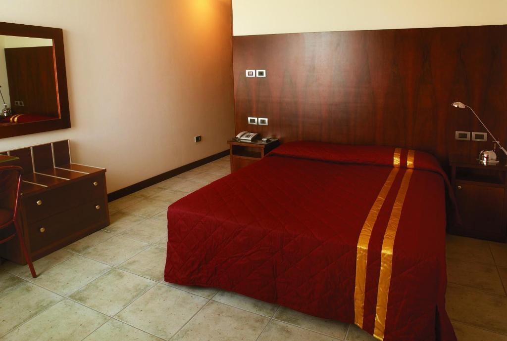 Bagnolo San VitoにあるLa Corte Albergo Meubléのベッドルーム(赤いベッド1台、鏡付)