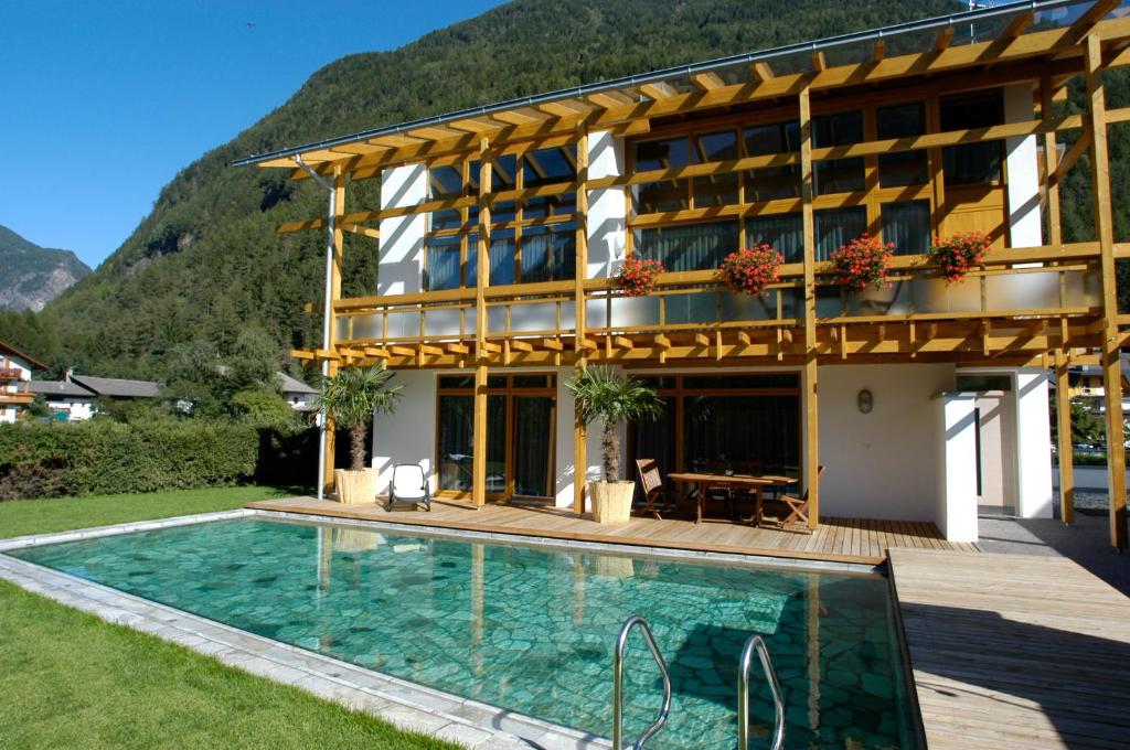 a house with a swimming pool in front of a building at Gasthof Residence Brugghof & Erlhof in Campo Tures