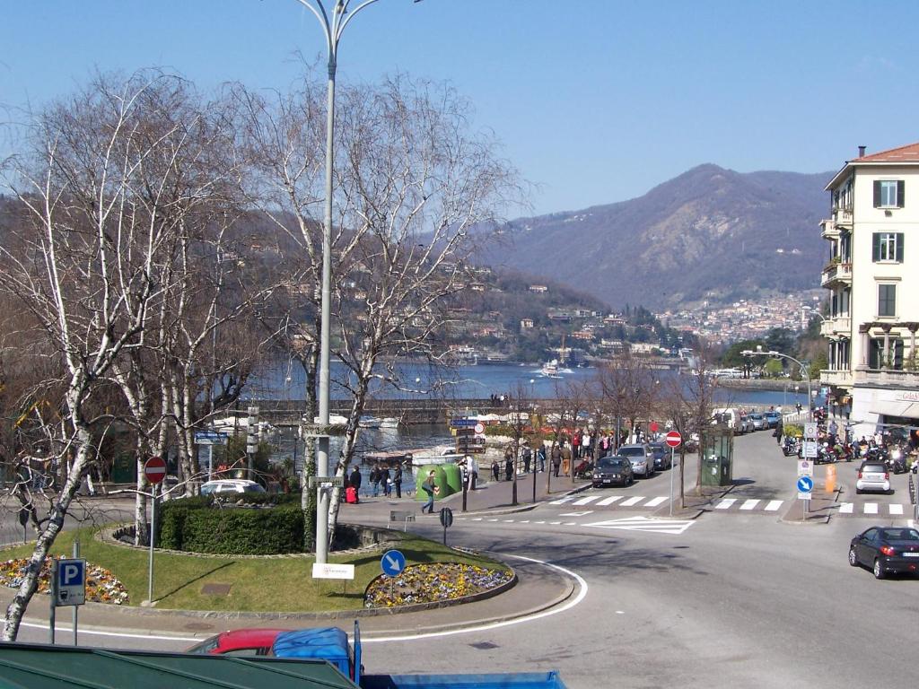 una strada in una città con un fiume e una montagna di Il Vecchio Borgo Relais a Como