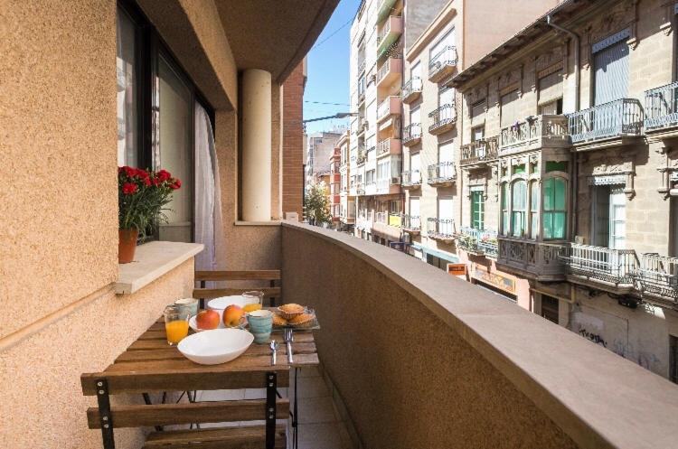 een tafel op het balkon van een gebouw met eten erop bij Cosy Friendly Centre Alicante in Alicante