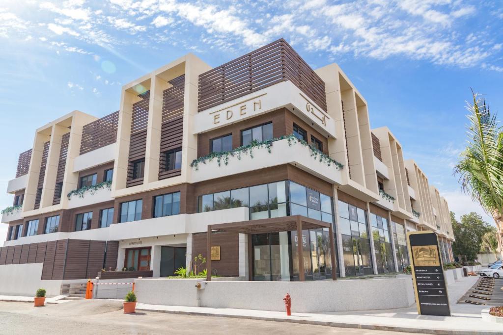 a building on a street with palm trees at Eden Residence in Jeddah