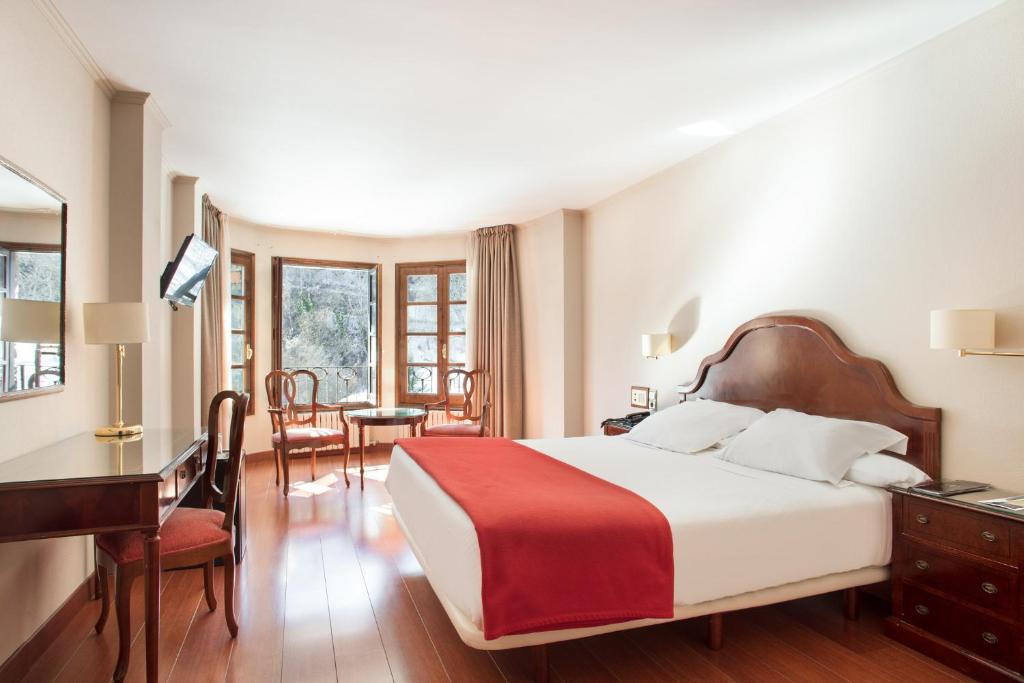 - une chambre d'hôtel avec un lit et un bureau dans l'établissement Abba Xalet Suites Hotel, à Sispony