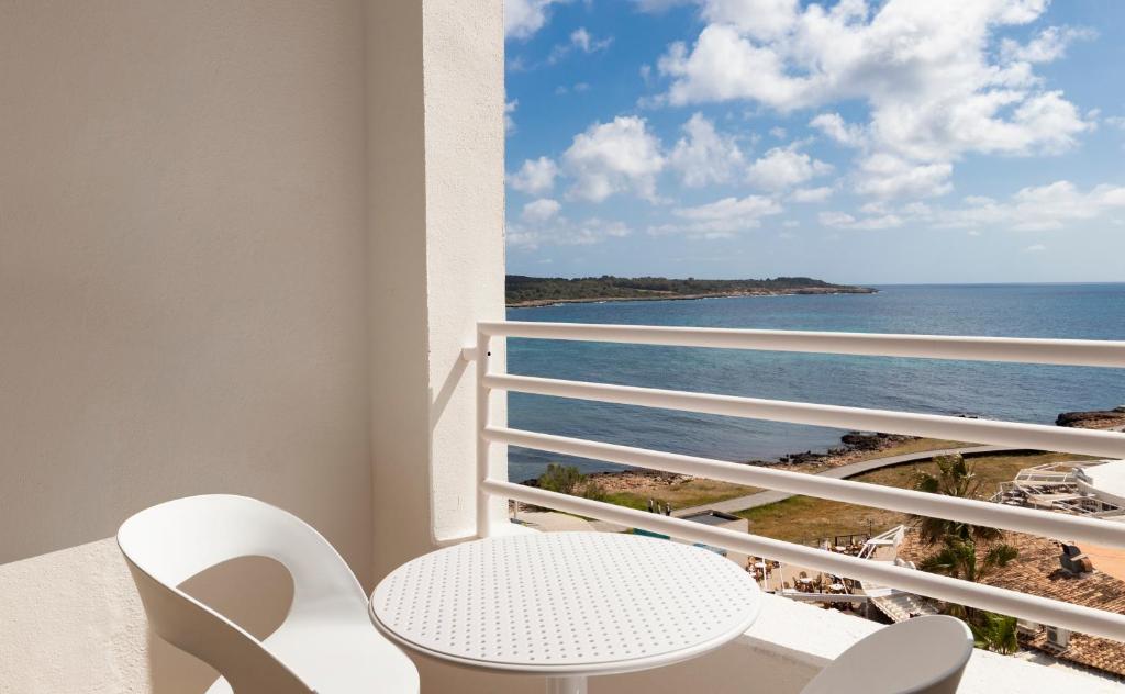 a room with a balcony with a view of the ocean at Hotel Palia Sa Coma Playa in Sa Coma