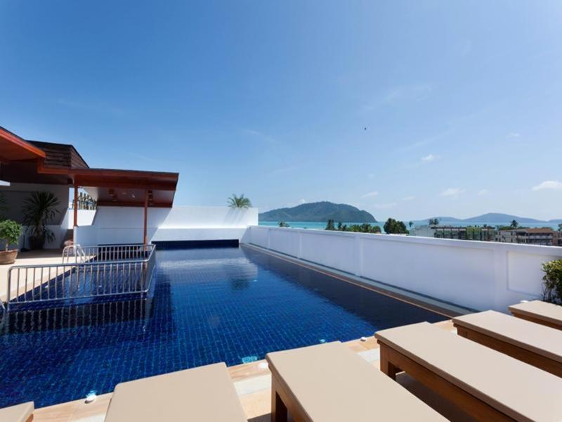 a swimming pool on the side of a building at Rawai Princess Hotel in Rawai Beach