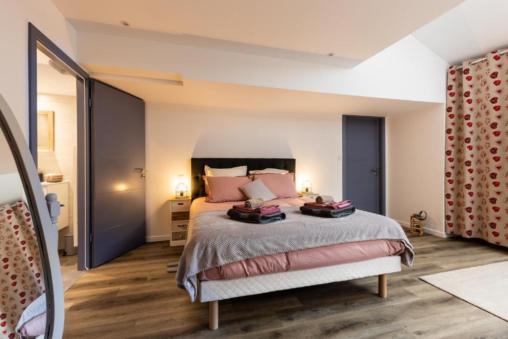 ein Schlafzimmer mit einem großen Bett mit rosa Kissen in der Unterkunft Les Chambres de Clem' in Bernardswiller