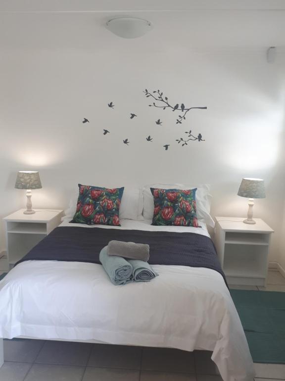 1 dormitorio con 1 cama blanca grande y 2 lámparas en NeverToforget Birds Haven, en Port Alfred