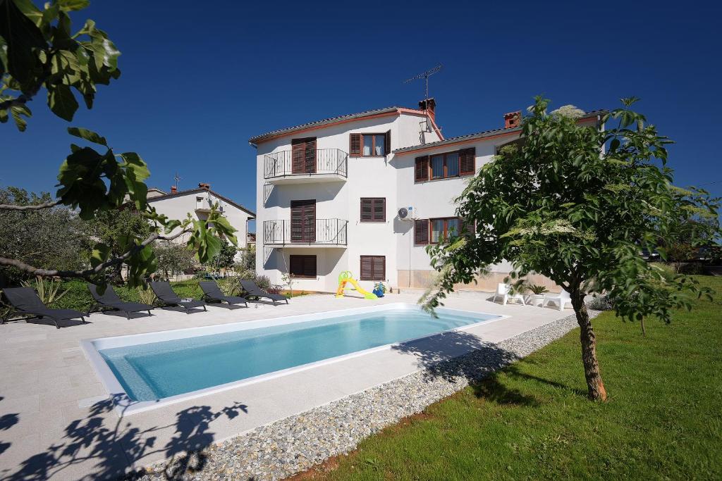 a villa with a swimming pool in front of a house at Apartment Falu in Štinjan