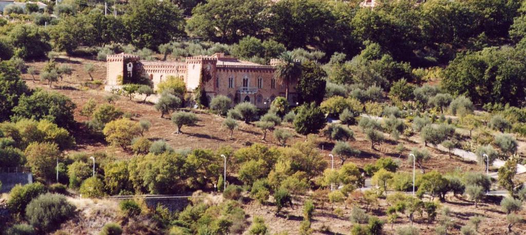 ein altes Gebäude inmitten eines Baumfeldes in der Unterkunft Villa Levante in Castelbuono