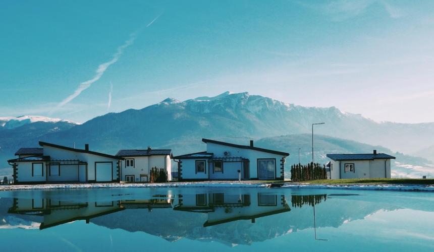 a row of houses with mountains in the background at منتجع سراييفو - Sarajevo Resort in Sarajevo