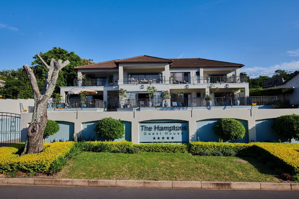 - un grand bâtiment blanc avec un panneau devant dans l'établissement The Hamptons Guest House, à Durban