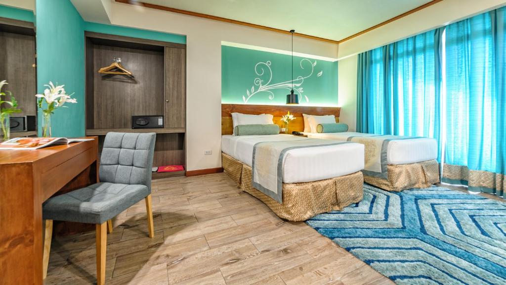 um quarto de hotel com duas camas e uma secretária em Sweet Home Boutique Hotel em Tagbilaran