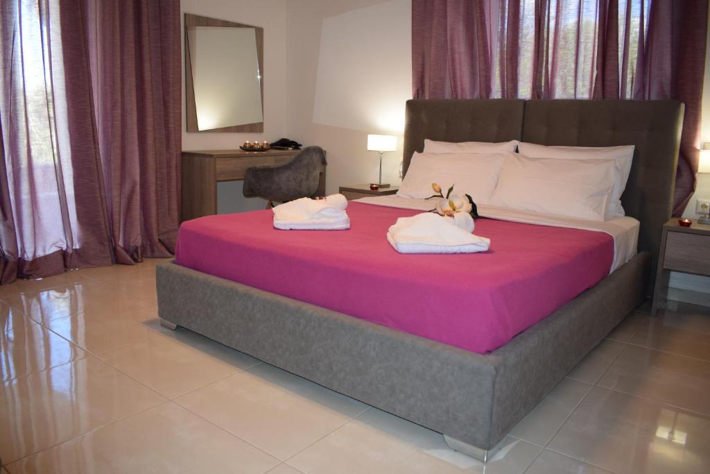a bedroom with a large bed with two towels at Studio Holiday Kalamata in Kalamata