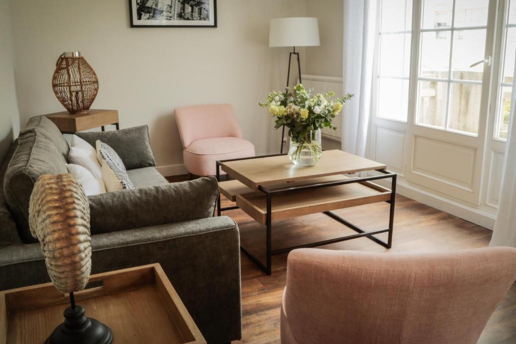 uma sala de estar com um sofá e uma mesa em LE PATIO DE CLARA em Le Touquet-Paris-Plage