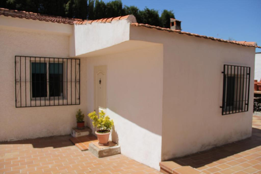 una casa bianca con una porta e una finestra di Studio Tropical a Cúllar-Vega