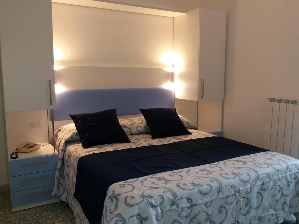 1 dormitorio con 1 cama grande y cabecero azul en Hotel Niagara, en Marotta