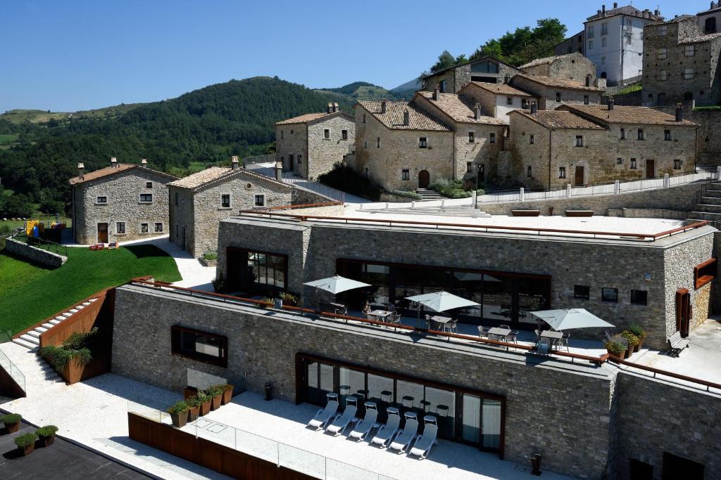 un bâtiment avec un groupe de chaises devant lui dans l'établissement Borgotufi Albergo Diffuso, à Castel del Giudice