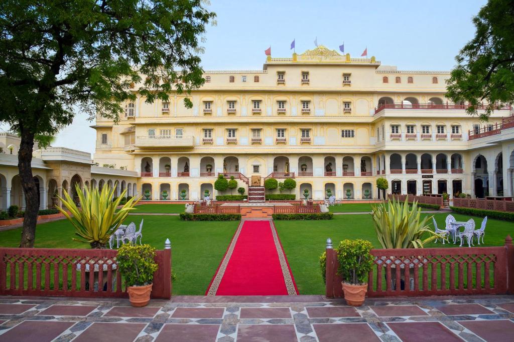 um grande edifício com um tapete vermelho em frente em The Raj Palace (Small Luxury Hotels of the World) em Jaipur