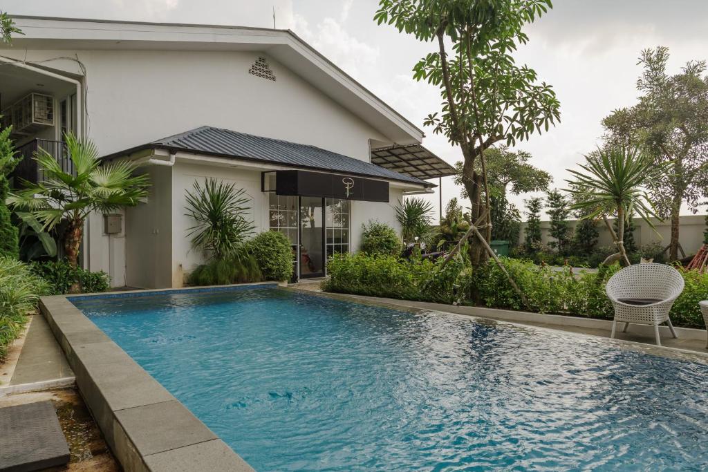 uma piscina em frente a uma casa em RedDoorz Plus near Exit Toll Puncak 2 em Bogor