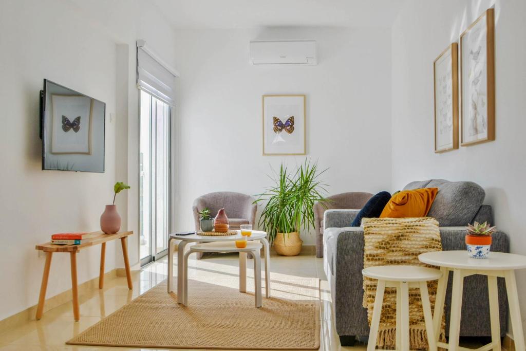 ein Wohnzimmer mit einem Sofa und 2 Tischen in der Unterkunft Phaedrus Living: Seaside Luxury Flat Lighthouse 67 in Paphos City