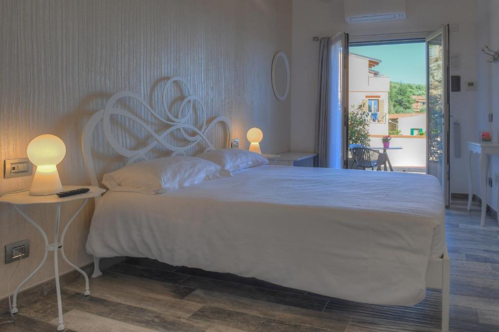 una camera da letto con un grande letto bianco con due lampade di La Locanda di Cucco a Finale Ligure