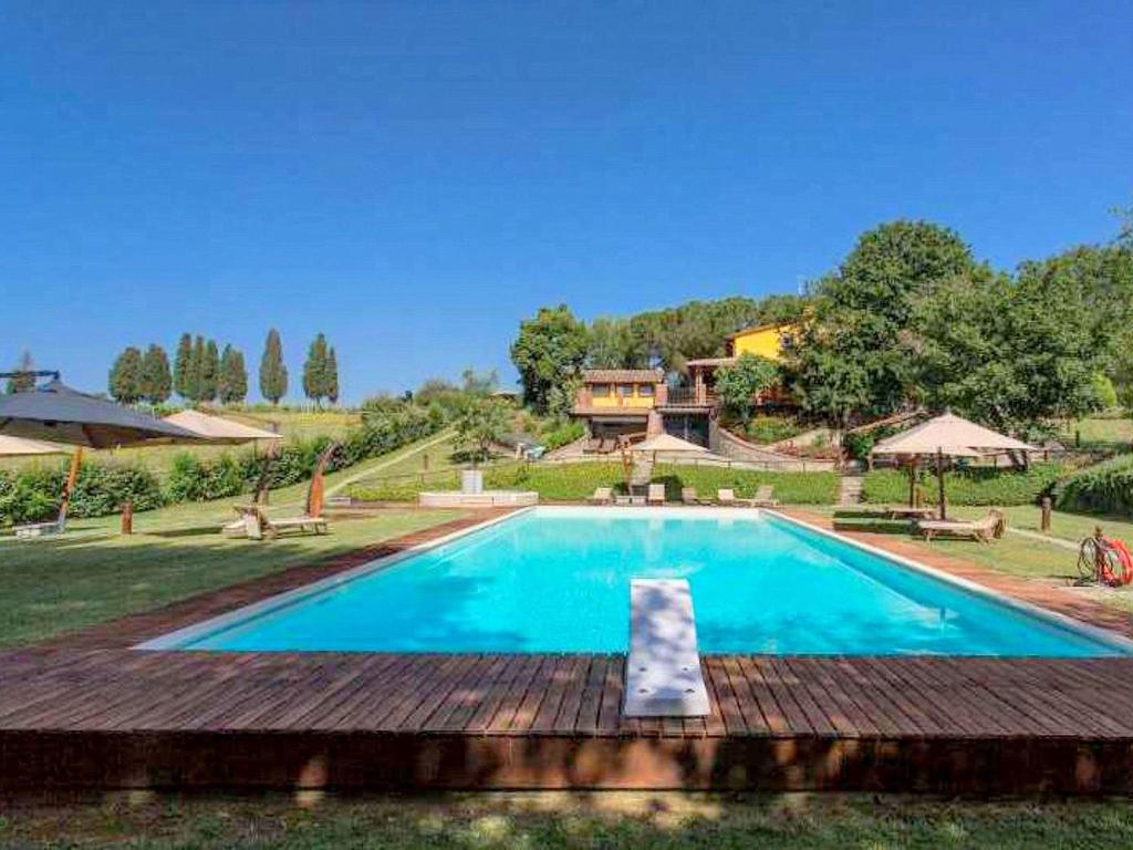 a swimming pool in a yard with a house in the background at Colours and scents from Tuscany await you in this wonderful property in Terranuova Bracciolini