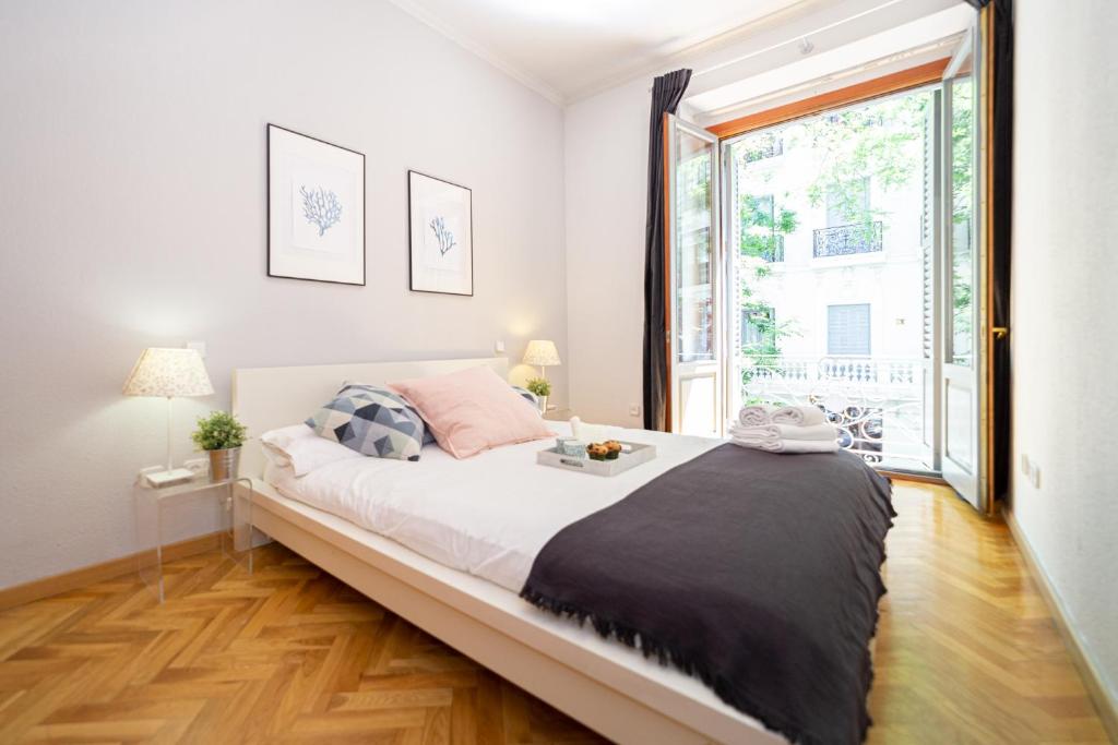 a large bed in a room with a large window at Apartamentos Plaza de España in Madrid