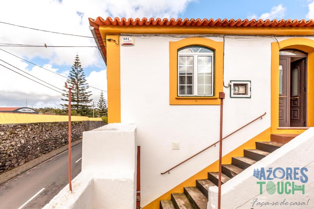 a small house with stairs and a window at House Rebelo in Terra Chã