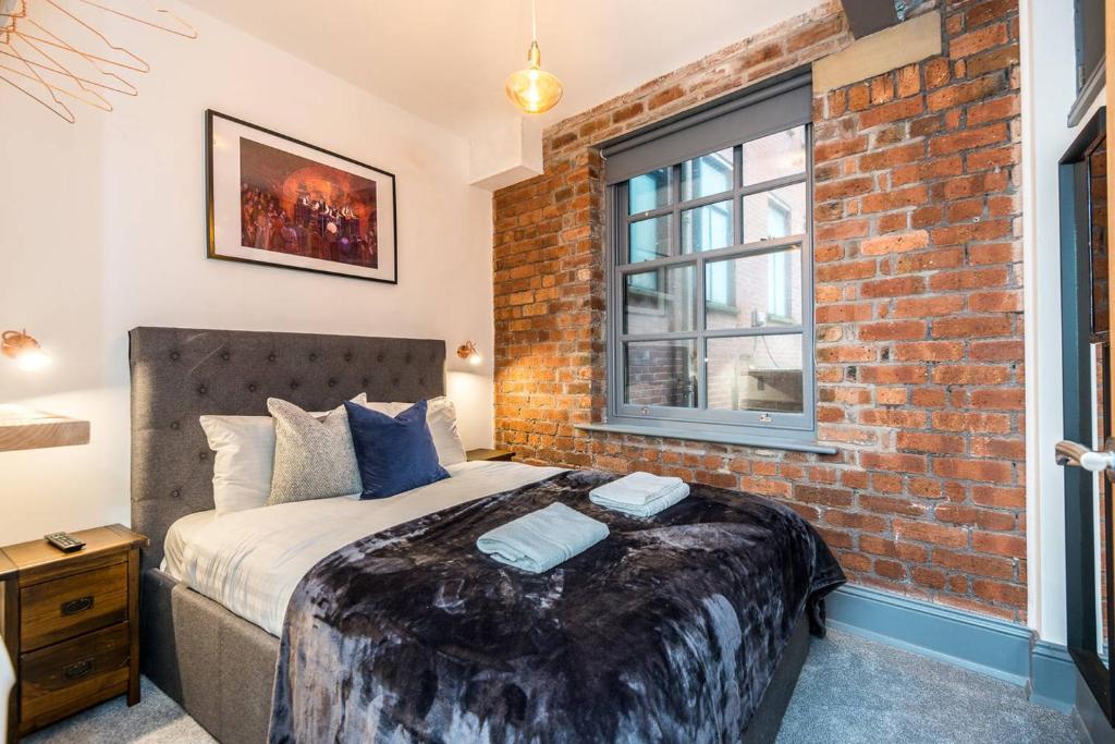 a bedroom with a bed with a brick wall at Host & Stay - Bands Warehouse I in Liverpool