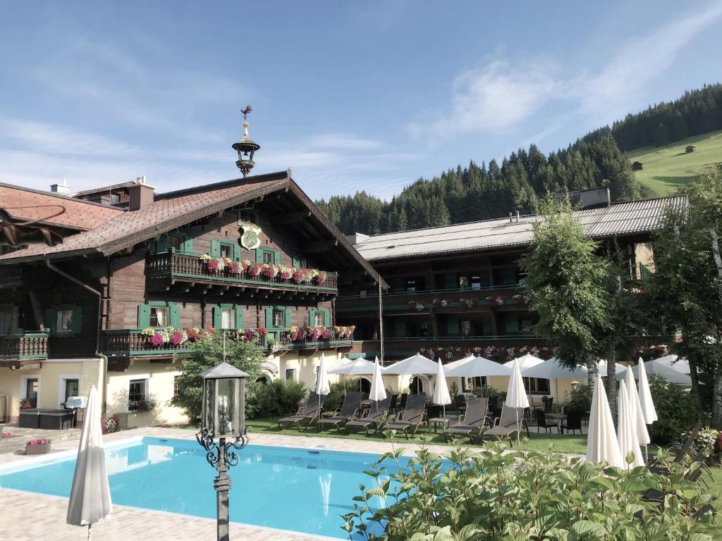 a hotel with a swimming pool in front of a building at Hotel Unterhof in Filzmoos