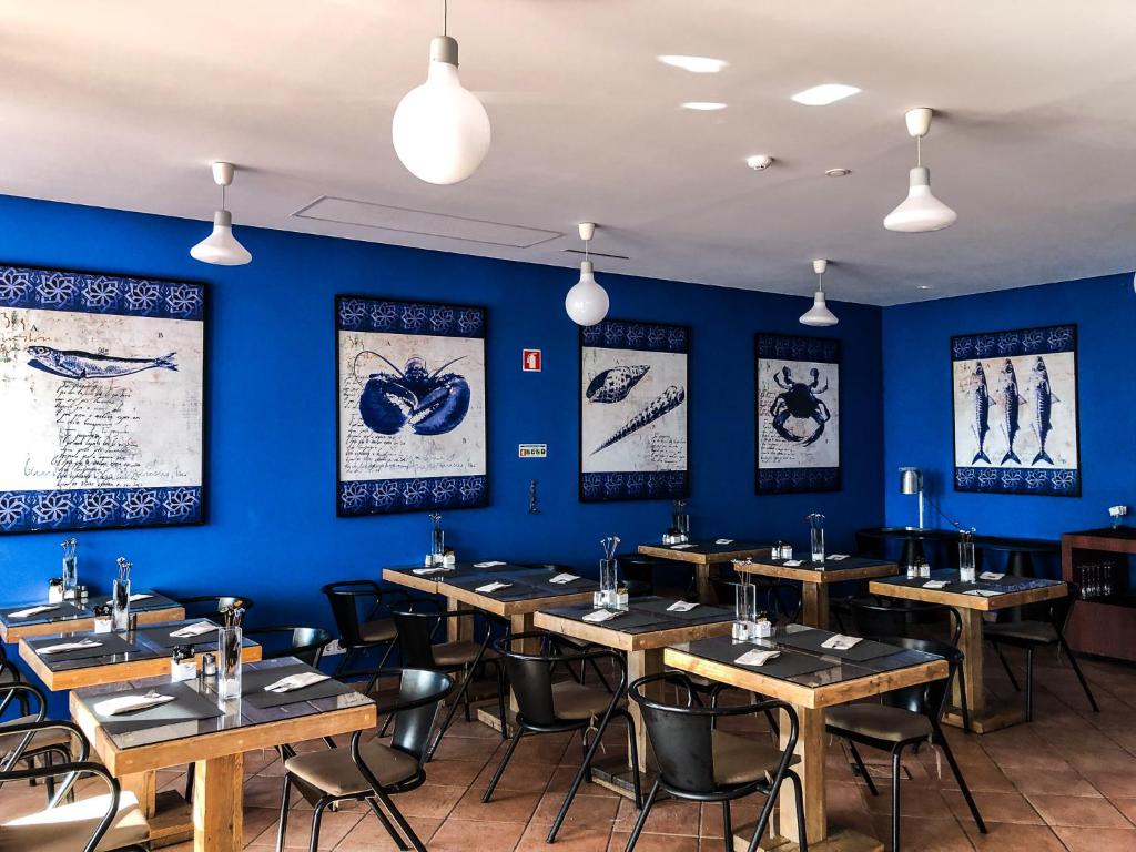 a dining room with wooden tables and blue walls at Vale d'El Rei Hotel & Villas in Carvoeiro
