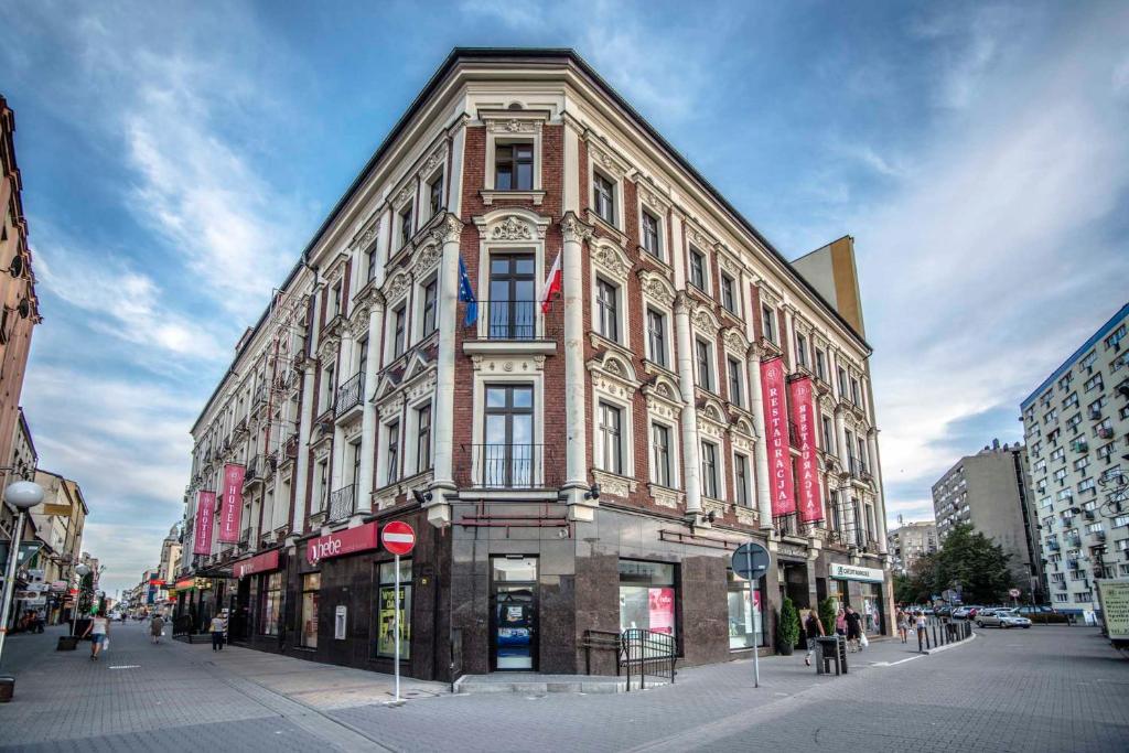 un gran edificio de ladrillo en una calle de la ciudad en Hotel Centrum Sosnowiec, en Sosnowiec