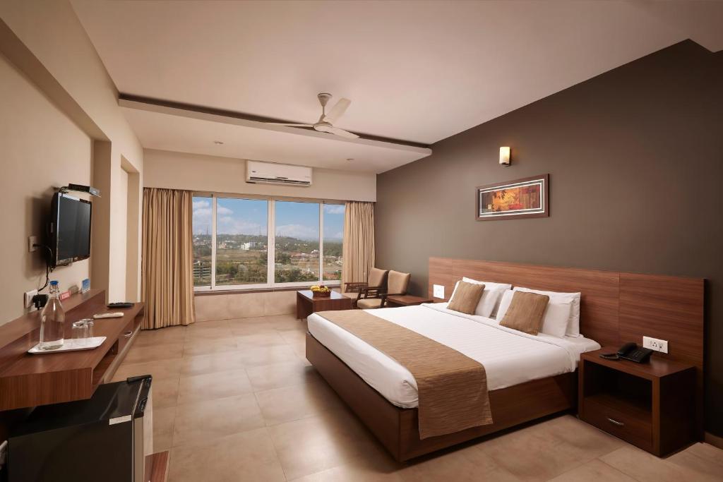 a hotel room with a bed and a television at Athome Comforts in Panaji