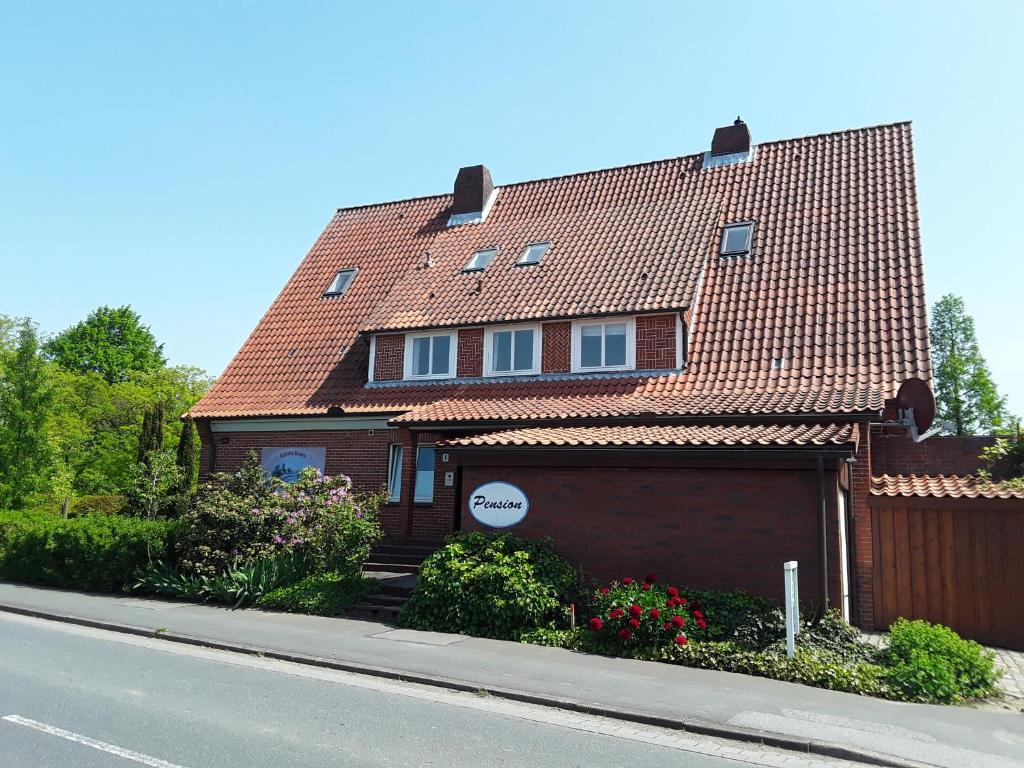 a brown house with a red roof on a street at Gästehaus am Alten Hafen in Jork