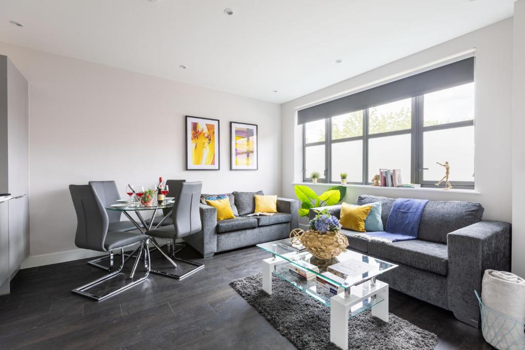 a living room with a couch and a table at homely - Watford Premier Apartments (Warner Bros Studio) in Watford