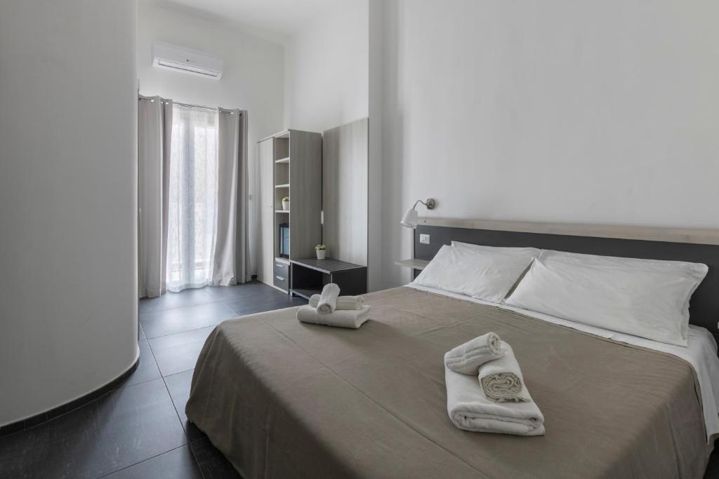 um quarto com uma cama grande e toalhas em B&B Vittoria em Gallipoli
