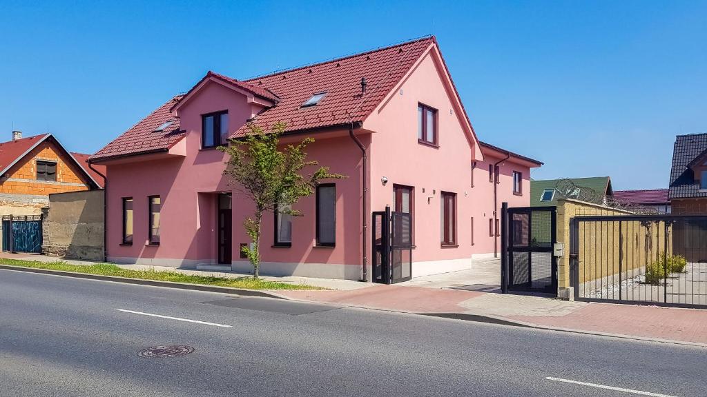 una casa rosa al lado de una calle en Apartment De Luna en Praga