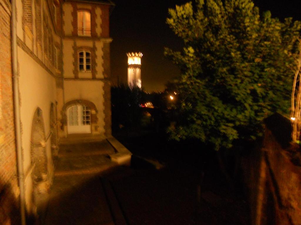 un edificio con un faro en el fondo por la noche en la maison du phare DE HONFLEUR chambre d hôtes B&amp;B -jacuzzi privé- shabby chic, en Honfleur