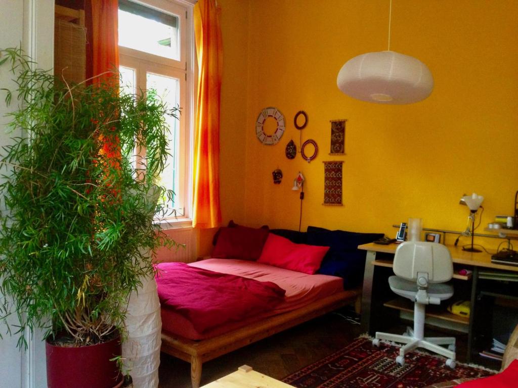 a living room with a red couch and a desk at Zimmer Nähe Stadtmitte in Freiburg im Breisgau