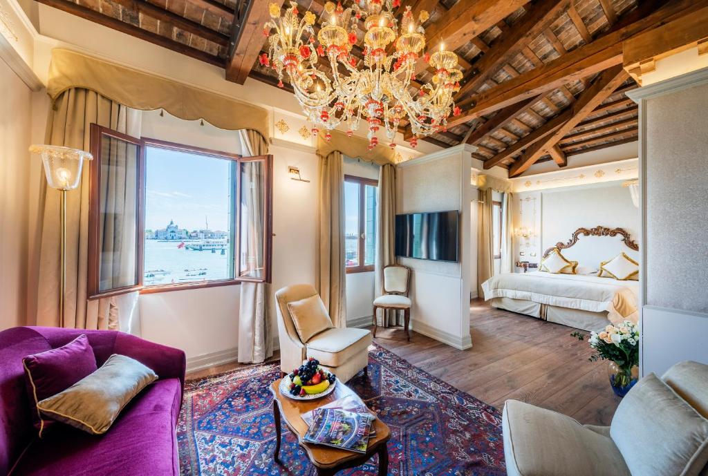 un soggiorno con divano viola e lampadario pendente di Monaco & Grand Canal a Venezia