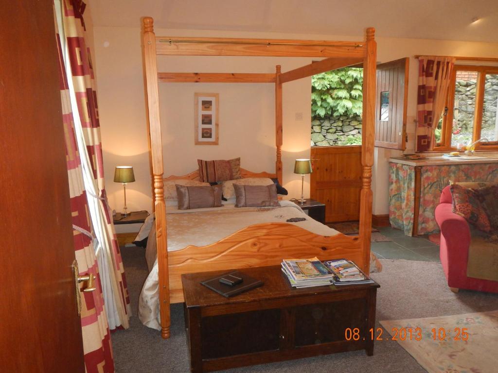 a bedroom with a large bed with a wooden frame at Stybeck Farm in Thirlmere