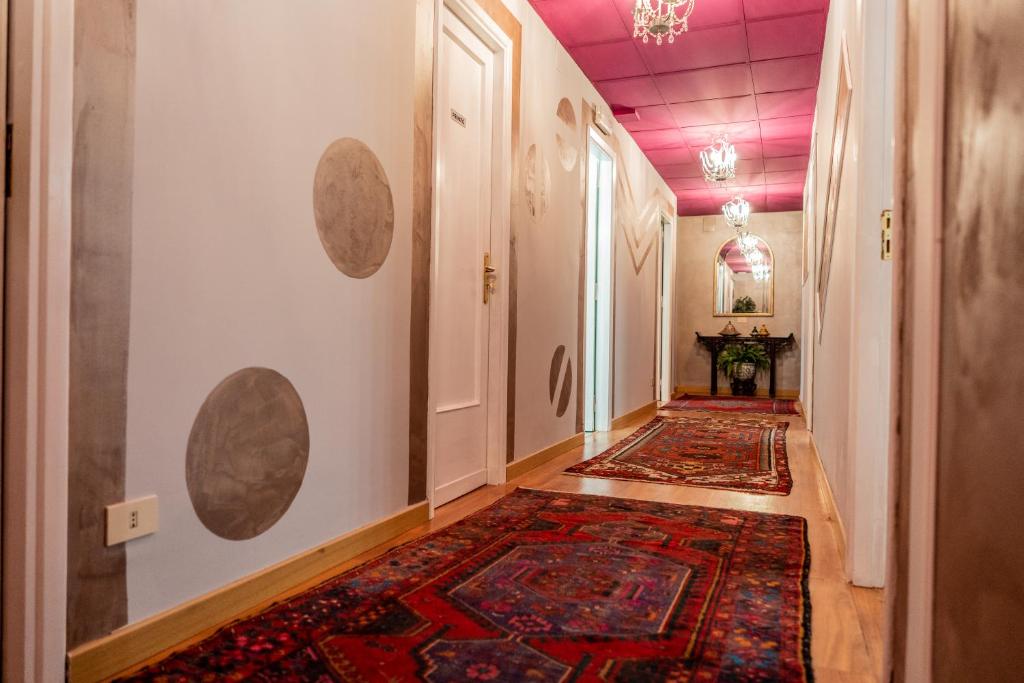 un corridoio vuoto con un tappeto sul muro e una stanza con di Le Finestre di Via Asiago a Catania