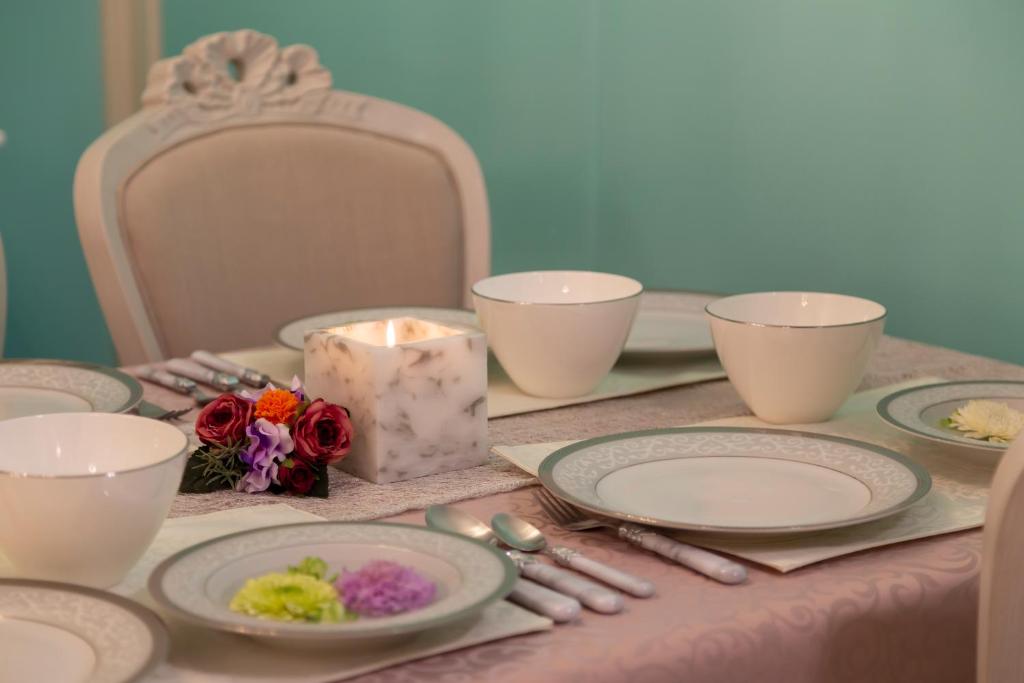 名古屋市にあるSakurAの皿、ろうそくと花のテーブル
